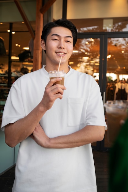 Front view smiley man with iced coffee