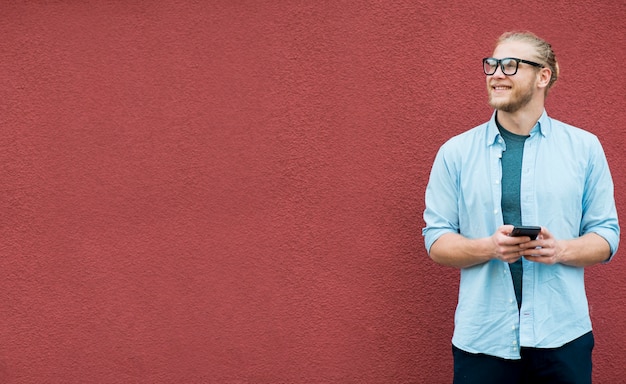 Front view of smiley man with smartphone and copy space