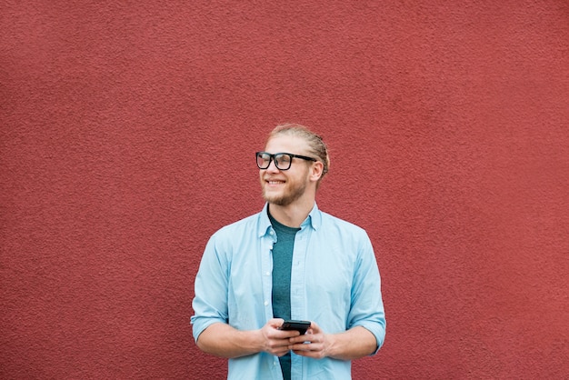 Front view of smiley man with smartphone