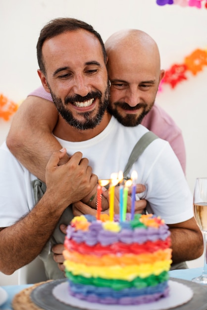 Free photo front view smiley men celebrating with cake