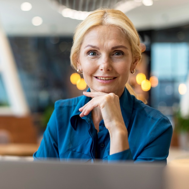 Front view of smiley older business woman posing at a diner