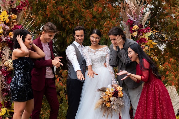 Free photo front view smiley people posing at wedding