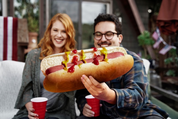 Front view smiley people with giant hot dog