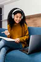 Free photo front view of smiley teenage girl with headphones during online school