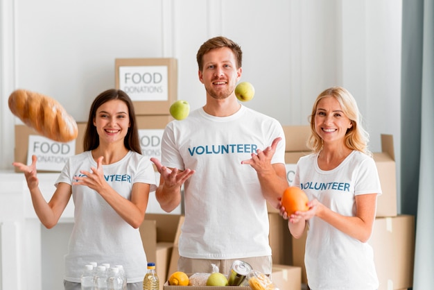 Front view of smiley volunteers helping with food donations