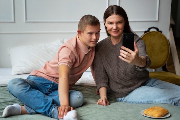 Front view smiley woman and boy taking selfie