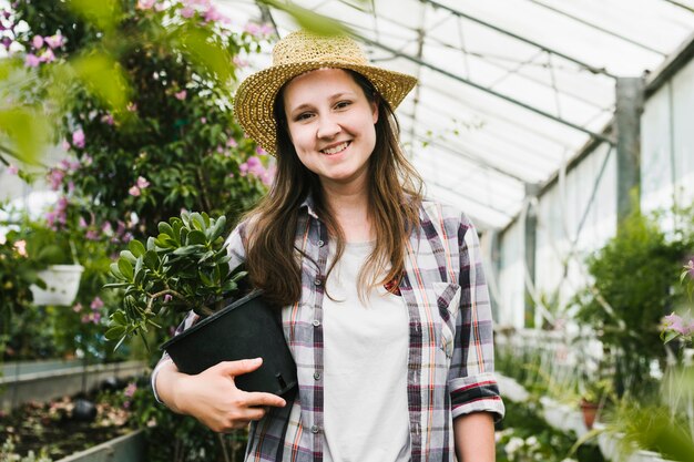 Front view smiley woman at greenhouse