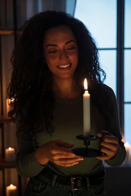 Free photo front view smiley woman holding candle