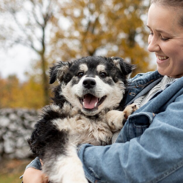 Front view smiley woman holding cute dog