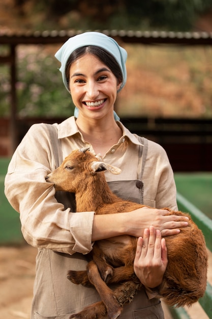 Free photo front view smiley woman holding goat