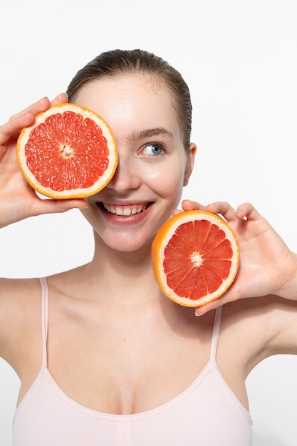 Front view smiley woman holding grapefruit