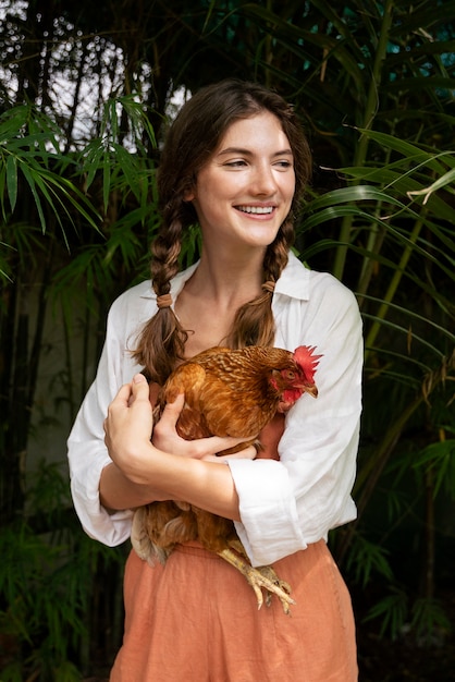 Free photo front view smiley woman holding hen