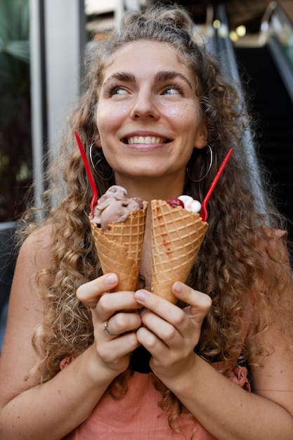 Front view smiley woman holding ice creams