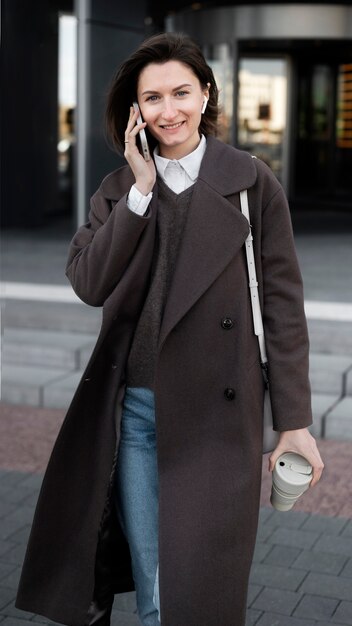 Front view smiley woman holding phone