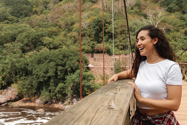 Free photo front view smiley woman looking at river