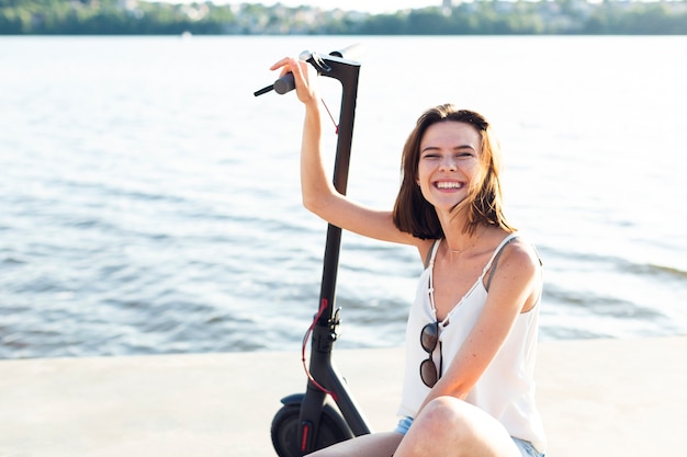 Free Photo front view smiley woman posing on scooter