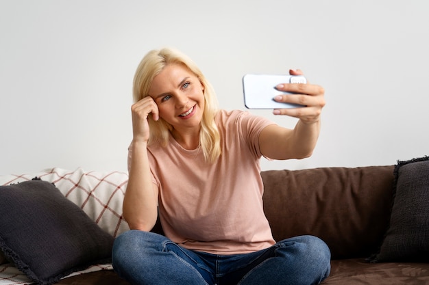 Free Photo front view smiley woman taking selfie