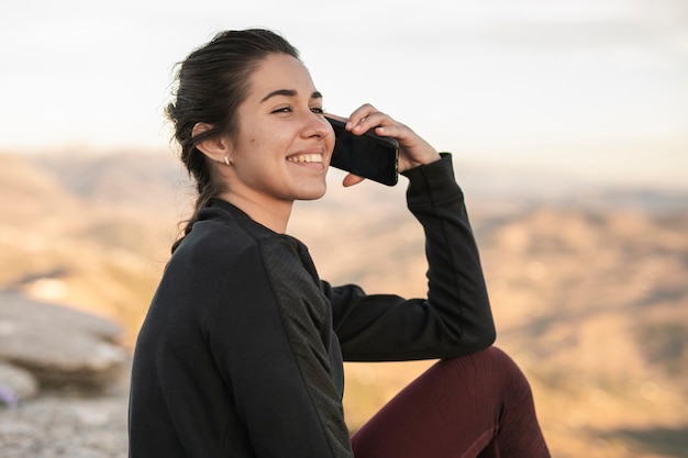 Front view smiley woman talking over phone