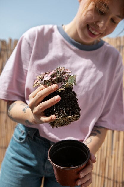 Front view smiley woman transplanting plant