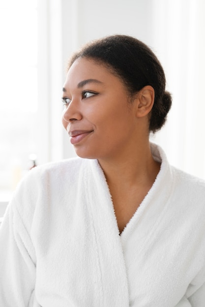 Front view smiley woman wearing bathrobe