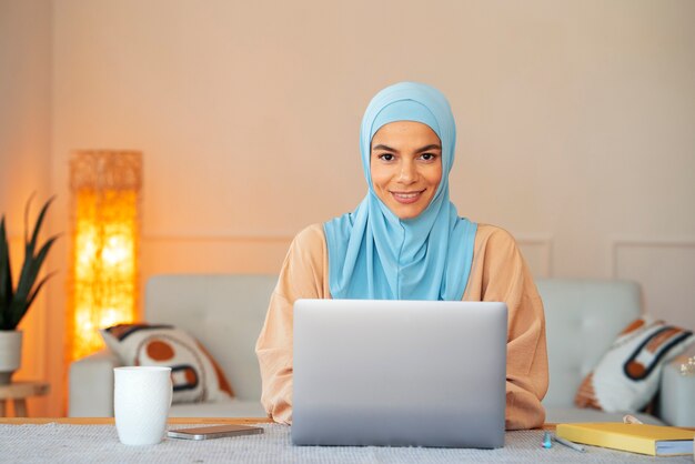 Front view smiley woman wearing hijab