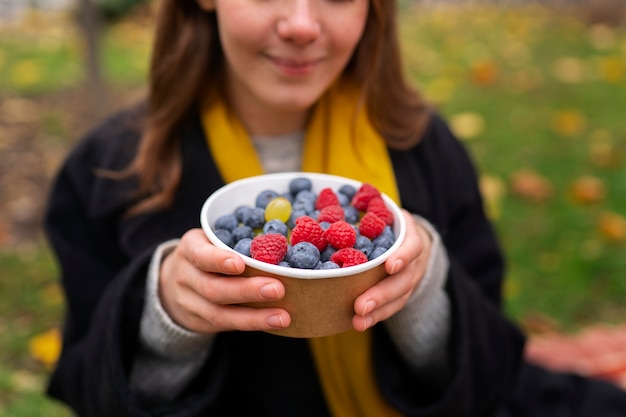 Free Photo front view smiley woman with berries outside