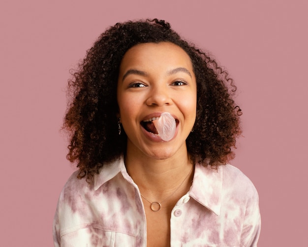 Free photo front view of smiley woman with chewing gum