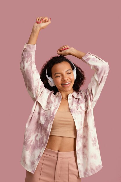 Front view of smiley woman with headphones dancing to music