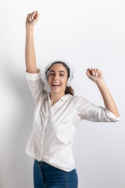 Front view of smiley woman with headphones dancing