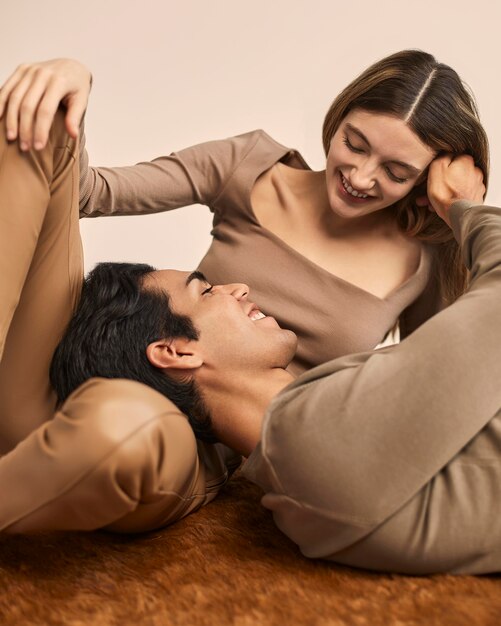 Front view of smiley woman with man resting his head on her lap