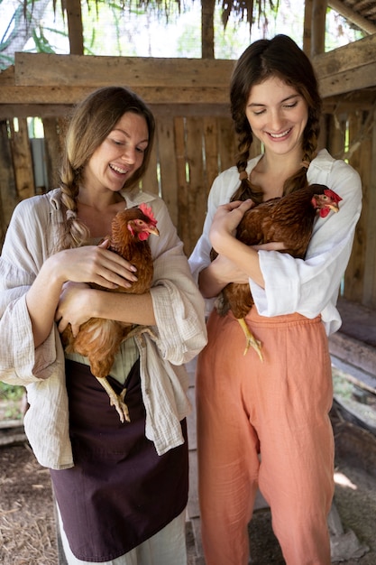 Free Photo front view smiley women holding chickens