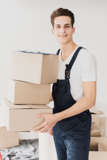 Free Photo front view smiley young man with boxes