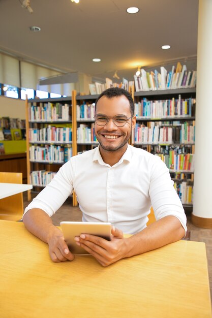 Front view of smiling cheerful man with tablet looking at camera