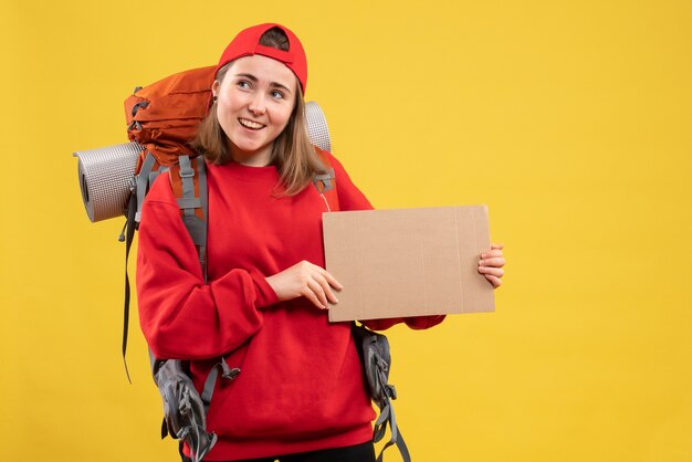 Front view smiling hitchhiker holding blank cardboard