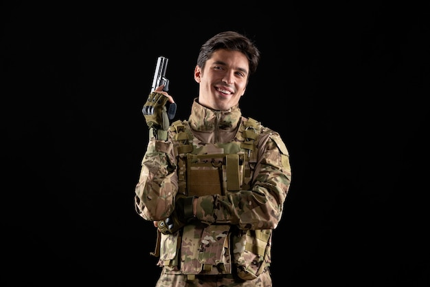 Free Photo front view of smiling military serviceman in uniform on black wall