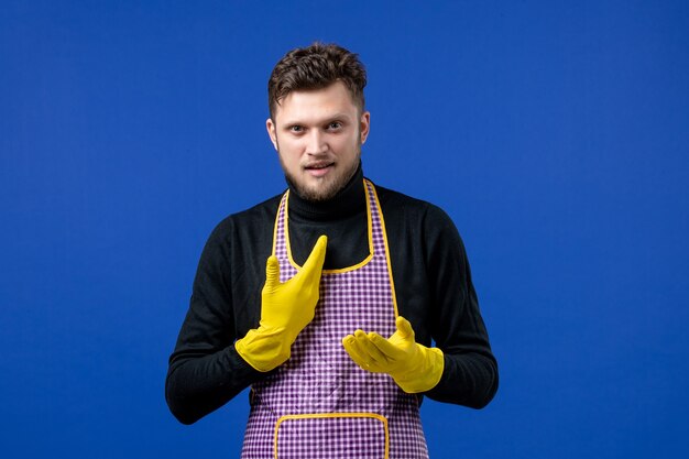 Free photo front view of smiling young male pointing at himself standing on blue wall