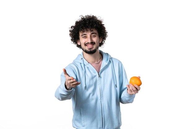 Front view smiling young man with fresh orange on white