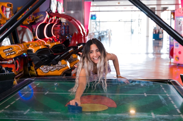 Free Photo front view smilling woman playing air hockey