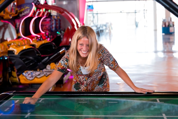 Free Photo front view smilling woman playing air hockey