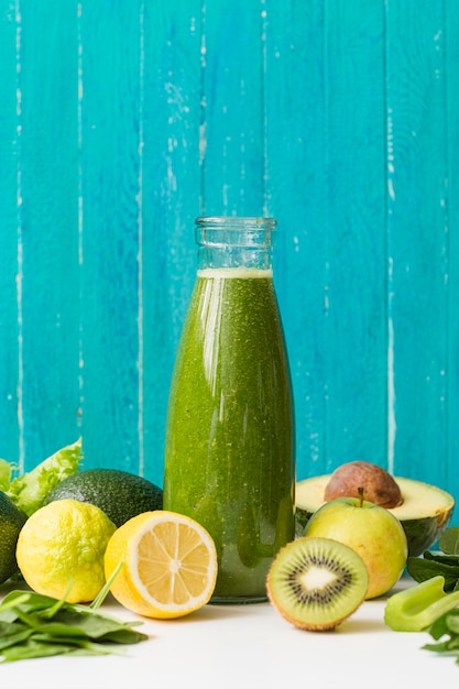 Free photo front view smoothie bottle with lemon and kiwi