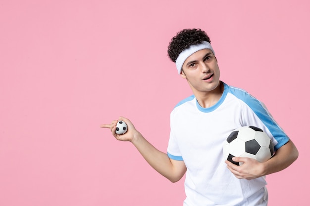 Front view soccer player in sport clothes with ball