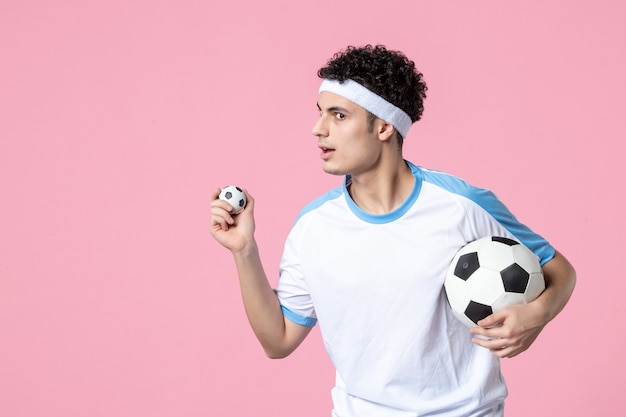 Front view soccer player in sport clothes with ball