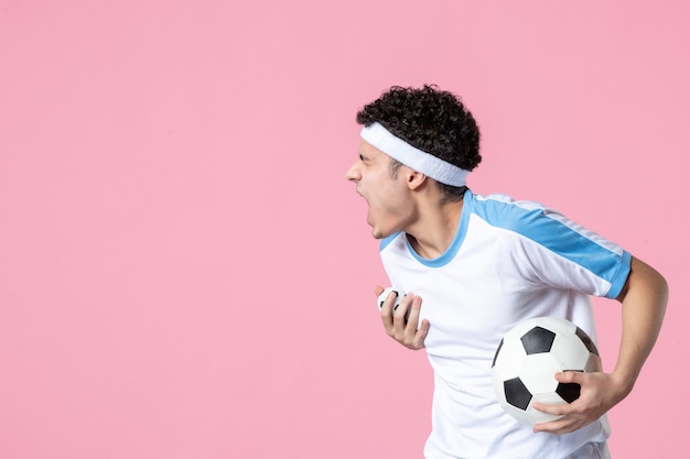 Front view soccer player in sport clothes with ball