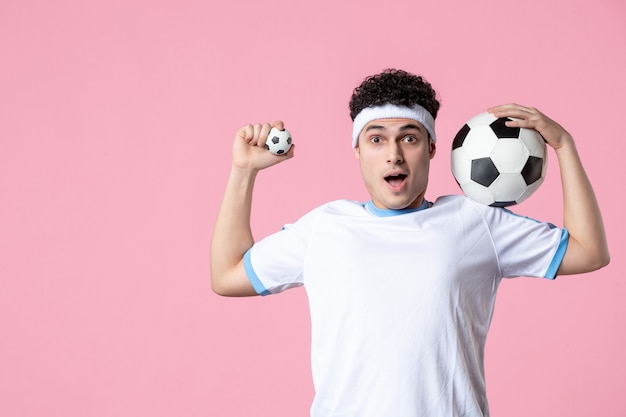 Front view soccer player in sport clothes with ball