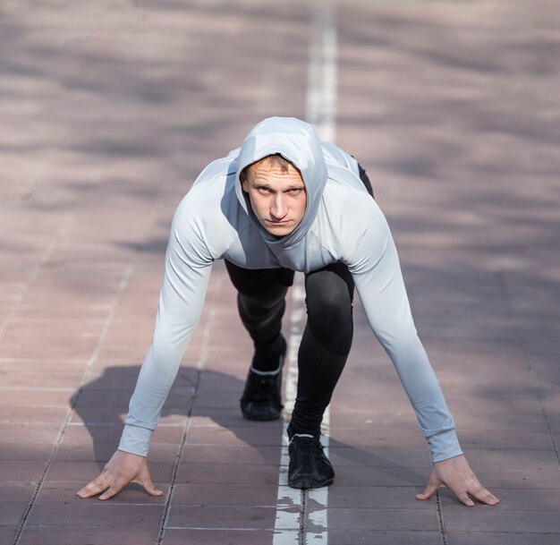 Front view sporty man preparing to run