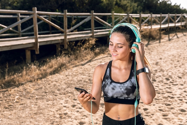 Free photo front view sporty woman listening to music