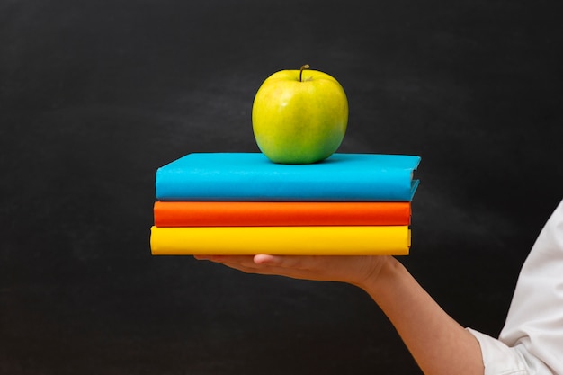 Free photo front view stack of books with apple on top