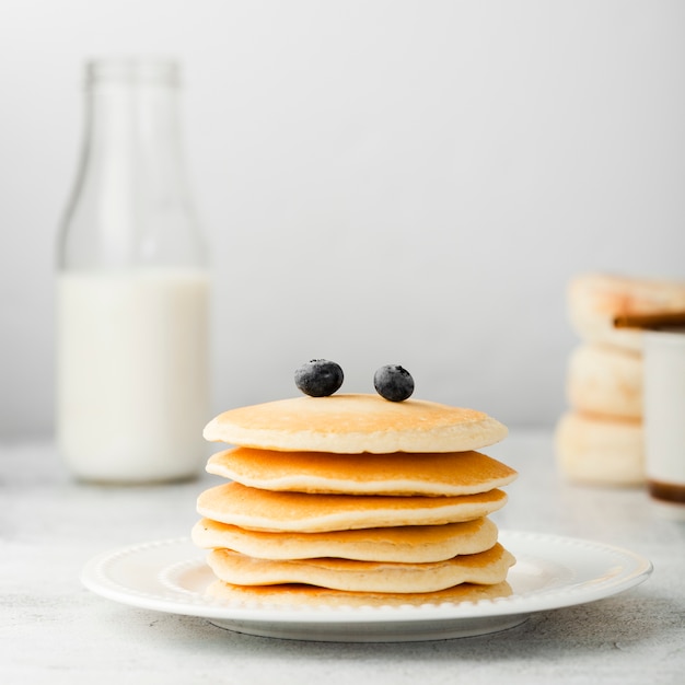 Free photo front view stack of pancakes with cranberries on top