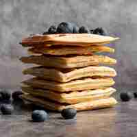 Free photo front view of stacked waffles with blueberries on top