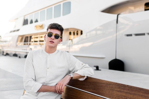 Free Photo front view of stylish man posing with sunglasses outdoors